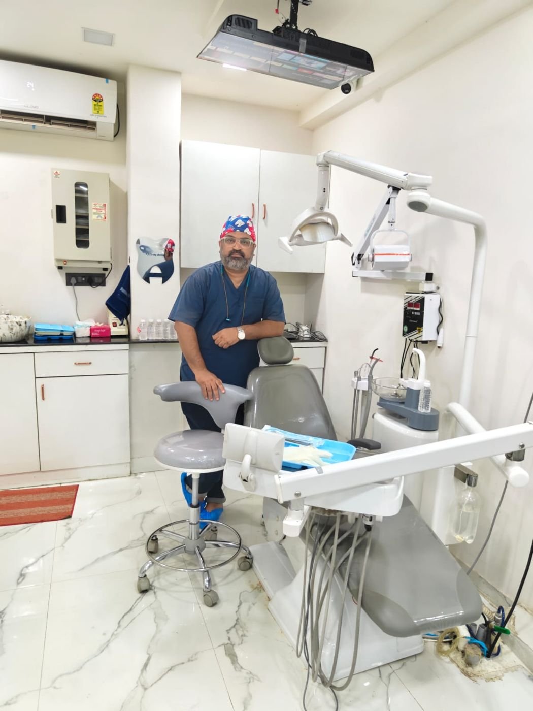 Dr. Prashant Gotise standing beside a dental chair in his operatory