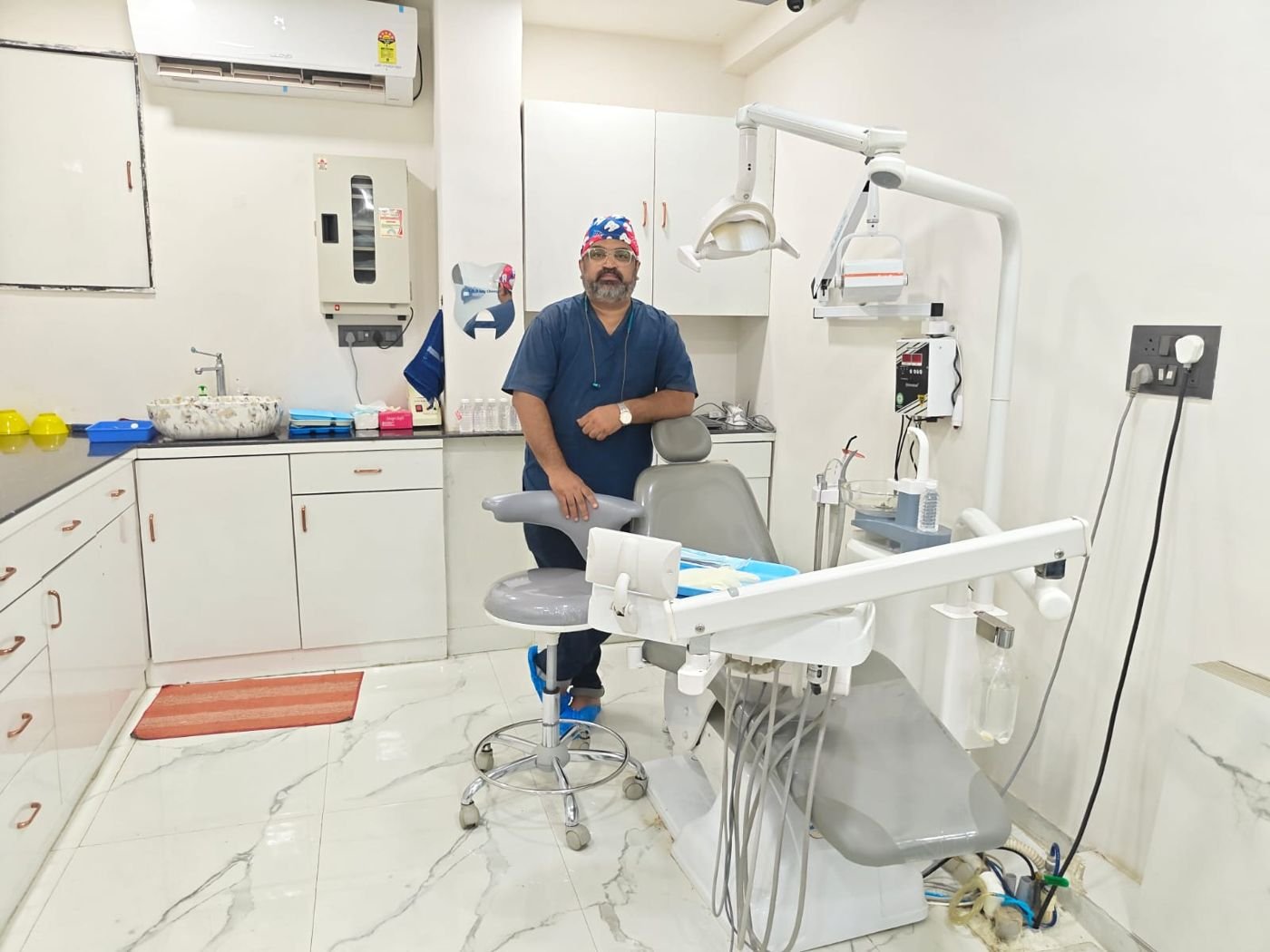 Dr. Gotise in the operatory next to the dental chair