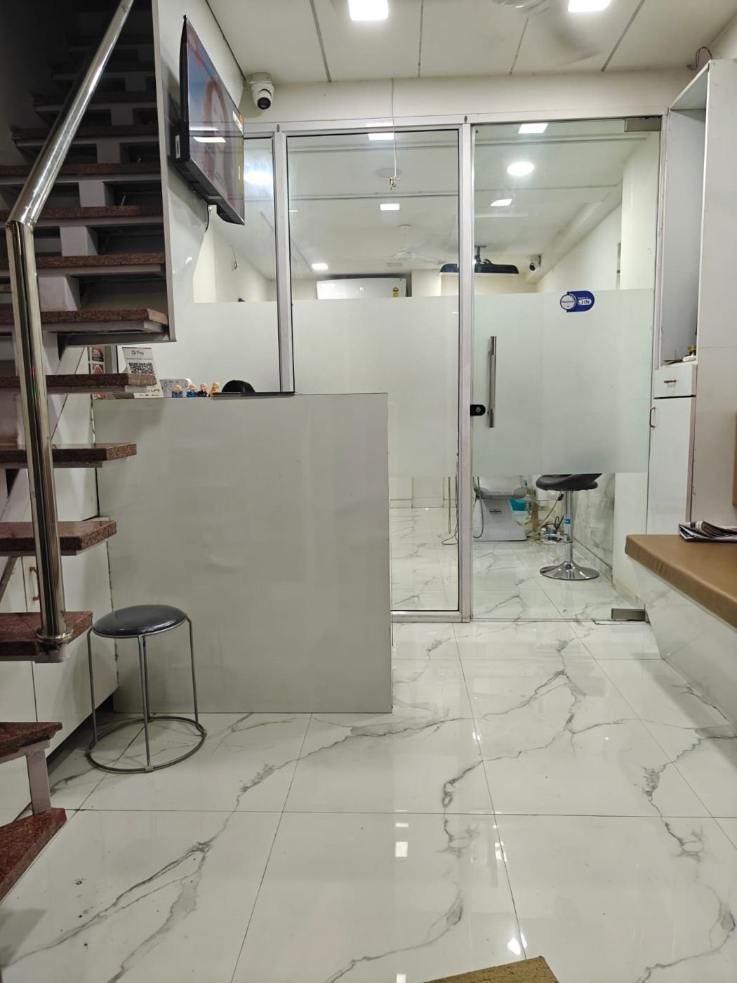 Reception desk with glass partitions and marble floor